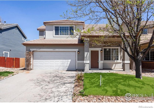 traditional home with fence, a tile roof, a garage, stucco siding, and driveway