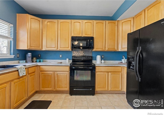 kitchen with light brown cabinetry, light tile patterned flooring, black appliances, and light countertops
