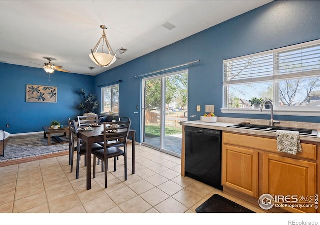 kitchen with black dishwasher, light tile patterned flooring, a sink, and light countertops