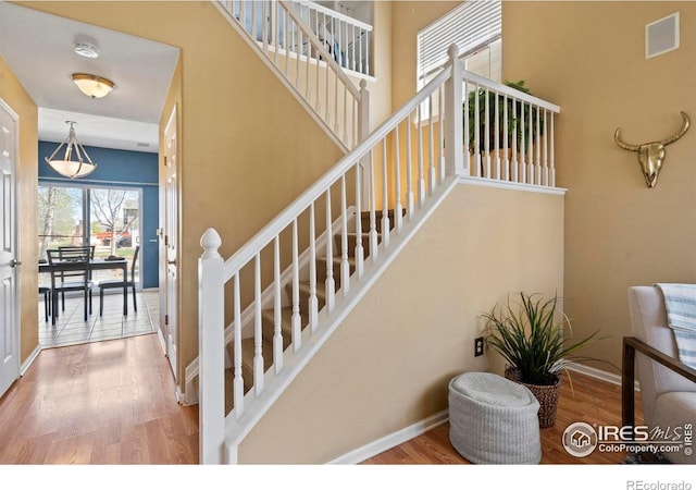 staircase featuring baseboards and wood finished floors
