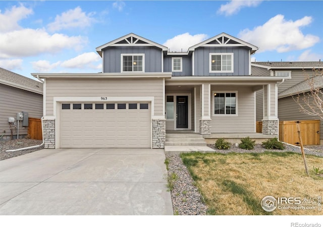 craftsman inspired home featuring board and batten siding, driveway, covered porch, and stone siding