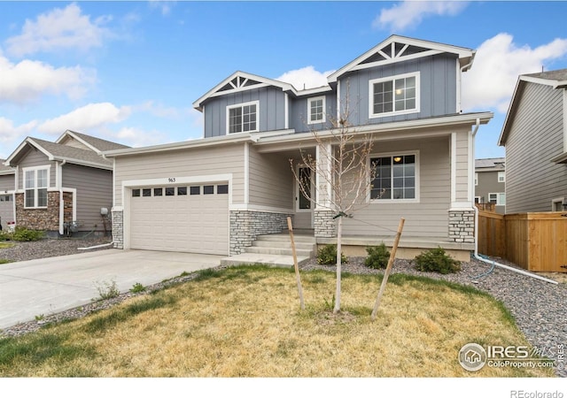 craftsman-style home featuring fence, a front lawn, stone siding, board and batten siding, and concrete driveway