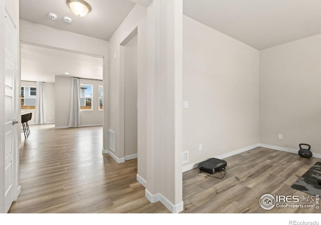 interior space featuring baseboards, visible vents, and light wood-style flooring