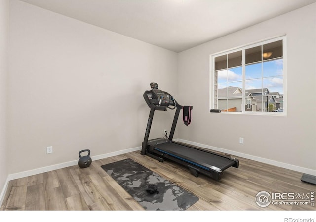 exercise area with baseboards and wood finished floors