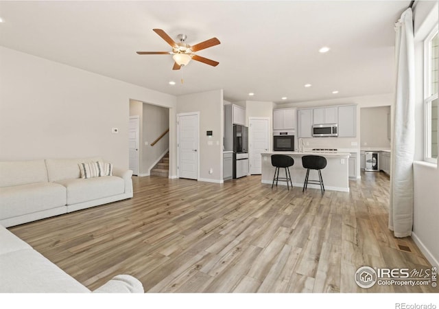 living area with stairs, recessed lighting, and light wood finished floors
