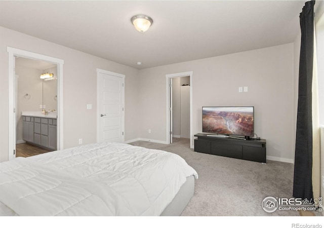 carpeted bedroom featuring baseboards and ensuite bath
