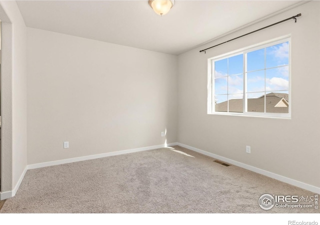 empty room featuring carpet floors, baseboards, and visible vents