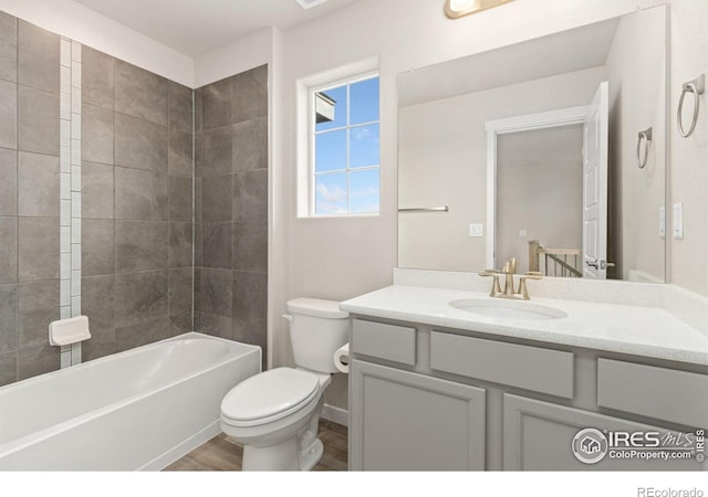 bathroom with vanity, shower / bathing tub combination, wood finished floors, and toilet