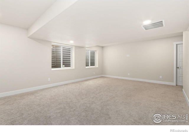 empty room with carpet flooring, recessed lighting, baseboards, and visible vents