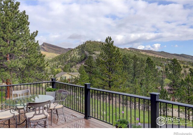 wooden deck featuring a mountain view and outdoor dining space
