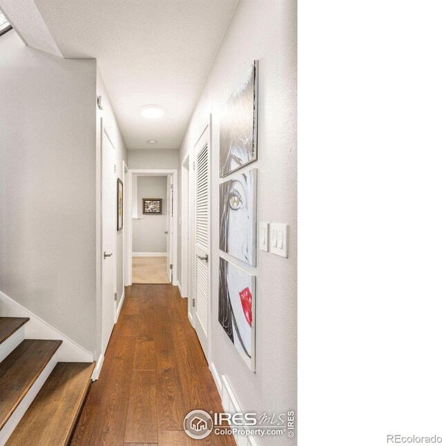 hall featuring baseboards and dark wood-style floors
