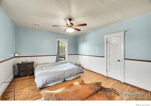 23730 County Road 41, La Salle, CO 80645 - bedroom featuring wood finished floors, a textured ceiling, visible vents, a ceiling fan, and baseboards