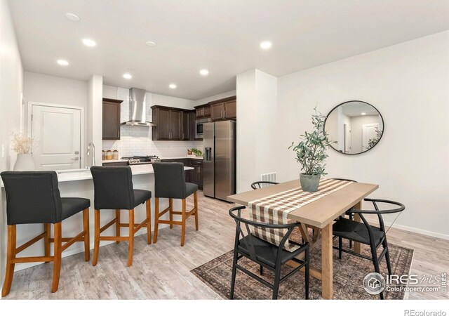 dining area with baseboards, recessed lighting, and light wood-style flooring