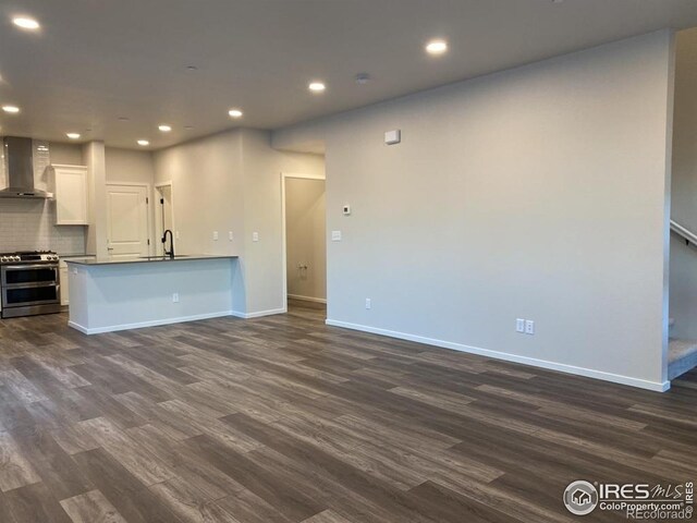 unfurnished living room with recessed lighting, baseboards, and dark wood-type flooring