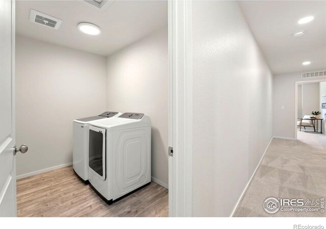 washroom with separate washer and dryer, laundry area, visible vents, and baseboards