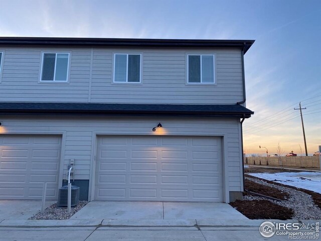 garage featuring central AC unit and concrete driveway