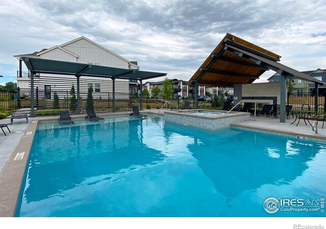 community pool with fence, a patio, and a community hot tub