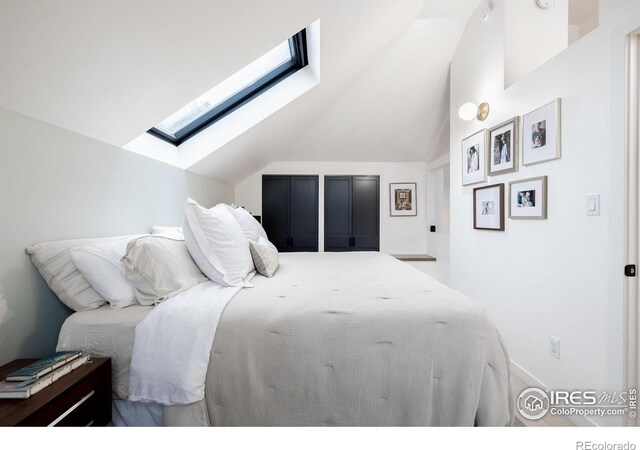 bedroom with vaulted ceiling with skylight