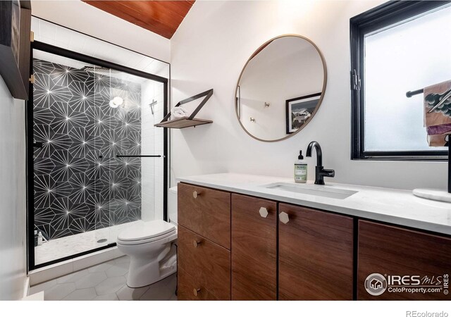 bathroom featuring vanity, tile patterned floors, a stall shower, and toilet