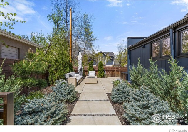 view of yard with fence, a patio, and outdoor lounge area