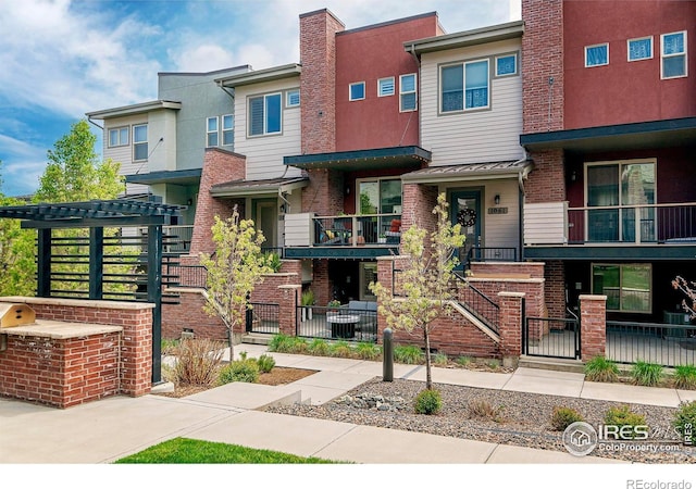 1069 Johnson Ln, Louisville, CO 80027 - townhome / multi-family property featuring brick siding, a fenced front yard, and a gate