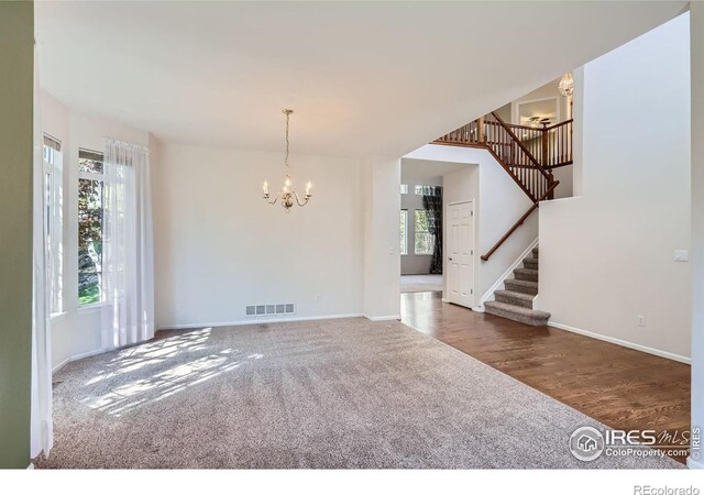 910 Pope Dr, Erie, CO 80516 - interior space featuring an inviting chandelier, carpet, baseboards, visible vents, and stairway