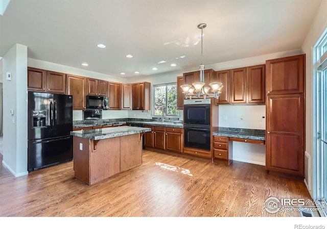 910 Pope Dr, Erie, CO 80516 - kitchen featuring an inviting chandelier, a center island, recessed lighting, black appliances, and decorative light fixtures