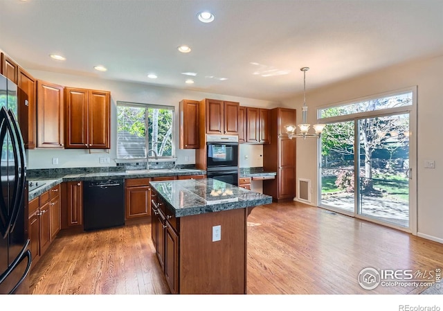 910 Pope Dr, Erie, CO 80516 - kitchen featuring a notable chandelier, plenty of natural light, black appliances, and light wood-style floors