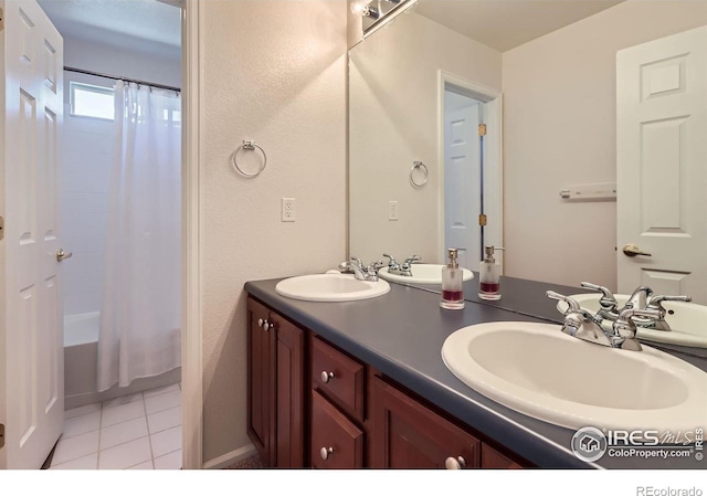 910 Pope Dr, Erie, CO 80516 - bathroom featuring double vanity, tile patterned floors, shower / bath combination with curtain, and a sink