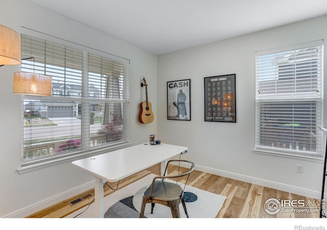 office featuring visible vents, light wood finished floors, and baseboards