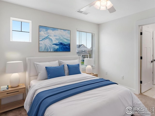 carpeted bedroom featuring ceiling fan, visible vents, and baseboards