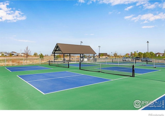 view of tennis court featuring fence and community basketball court