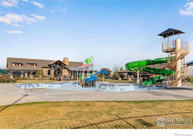 exterior space featuring stairs, a water play area, a water slide, and a yard