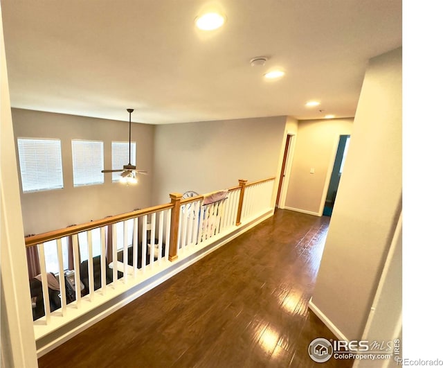 hall with a healthy amount of sunlight, baseboards, recessed lighting, and wood finished floors