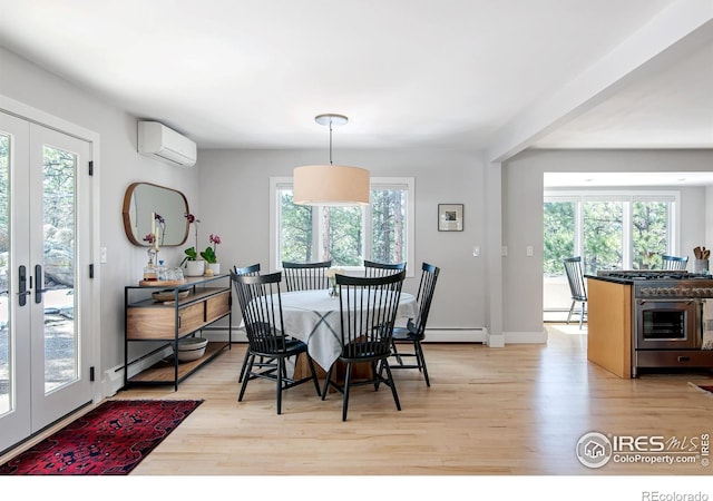 dining room featuring french doors, a baseboard radiator, light wood finished floors, and a wall unit AC