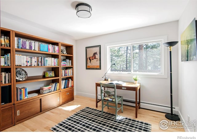 office space featuring baseboards, a baseboard radiator, and wood finished floors