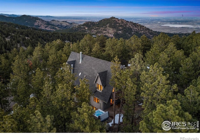drone / aerial view featuring a view of trees and a mountain view
