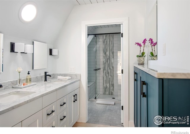 full bath with a sink, a stall shower, double vanity, and lofted ceiling