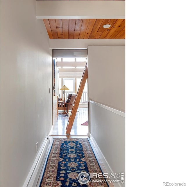 hallway with baseboards, baseboard heating, and wooden ceiling