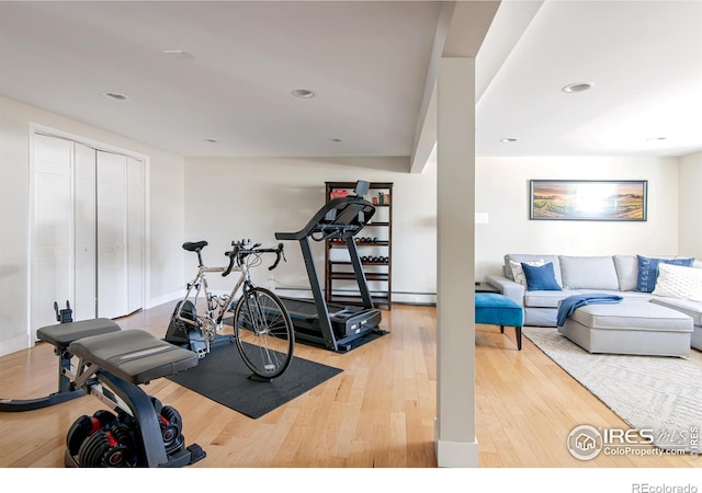 exercise area with baseboards, recessed lighting, and hardwood / wood-style floors