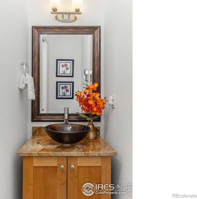 bathroom with a textured wall and vanity