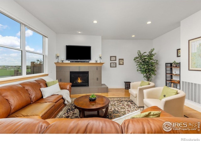 living room with recessed lighting, visible vents, and wood finished floors