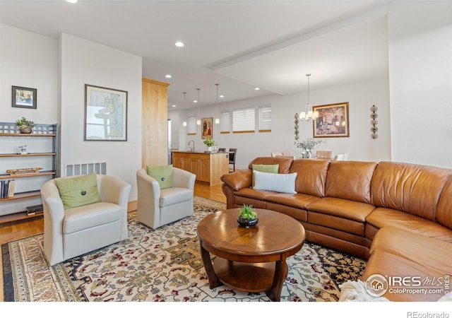 living area featuring recessed lighting, visible vents, an inviting chandelier, and light wood-style floors
