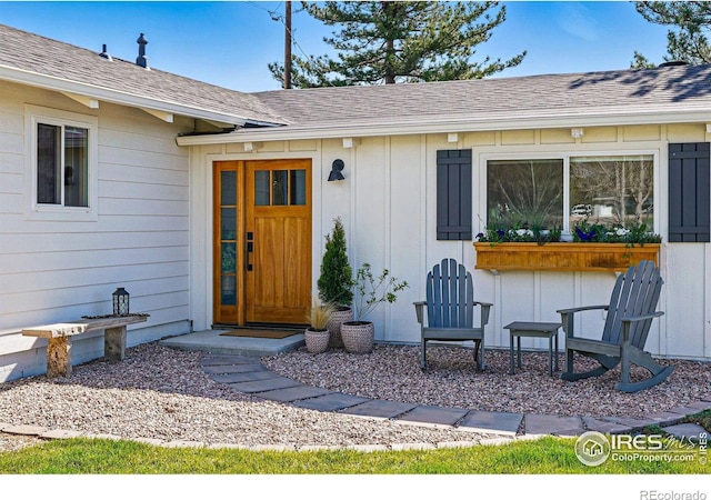 entrance to property featuring a shingled roof and board and batten siding