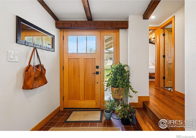 entrance foyer with baseboards, dark wood-style floors, and beam ceiling