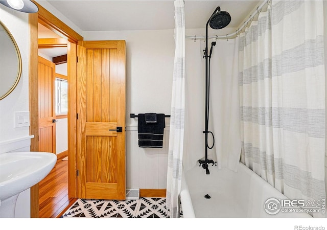 bathroom featuring a sink and shower / bathtub combination with curtain
