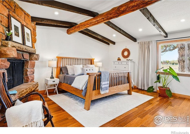 bedroom with baseboards, vaulted ceiling with beams, recessed lighting, and wood finished floors