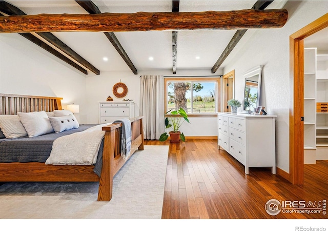 bedroom featuring beamed ceiling, recessed lighting, baseboards, and hardwood / wood-style floors