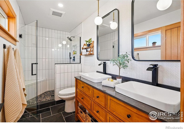 bathroom featuring tile patterned floors, visible vents, a sink, and a stall shower