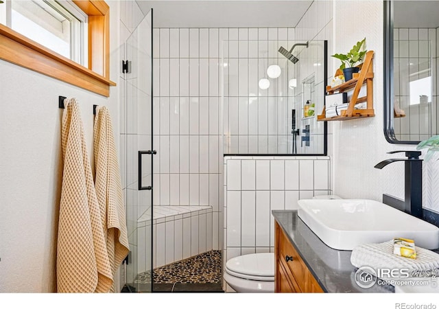 full bathroom with vanity, toilet, tile walls, and a stall shower